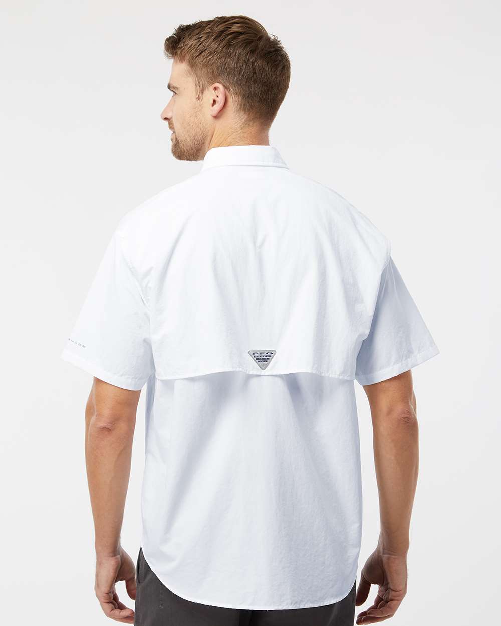 Man wearing a white shirt with a brand logo on a white background